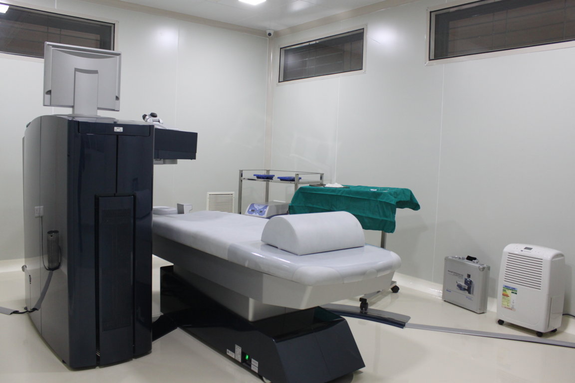 Climate-controlled LASIK chamber at Insight Institute with the WaveLight platform, prepared patient bed and a floor-standing dehumidifier in the corner